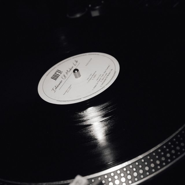 Disco de vinil girando no toca-discos, em preto e branco