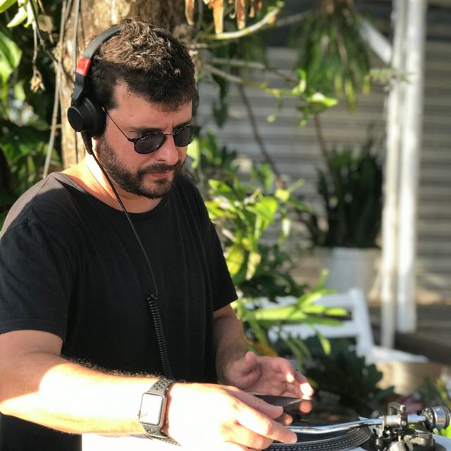Leo Reis de fone e óculos escuros, tocando vinil ao ar livre