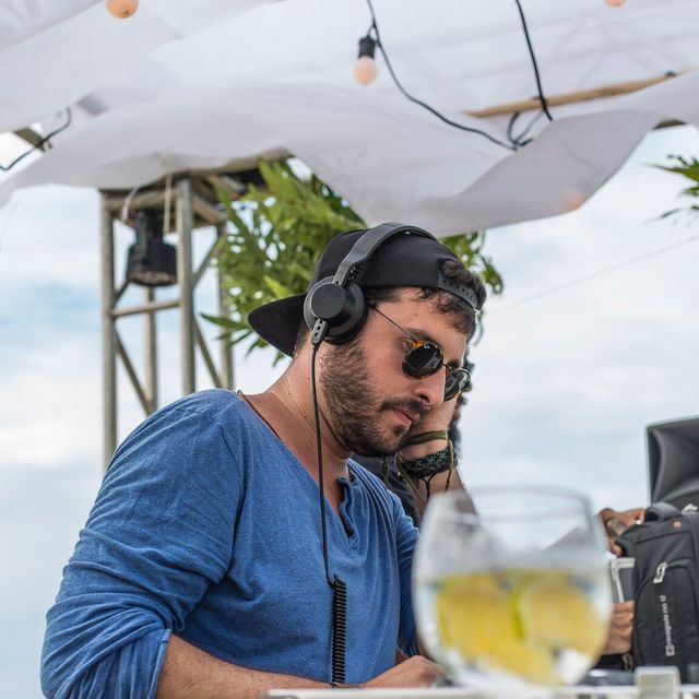 Leo Reis de fone, tocando na praia