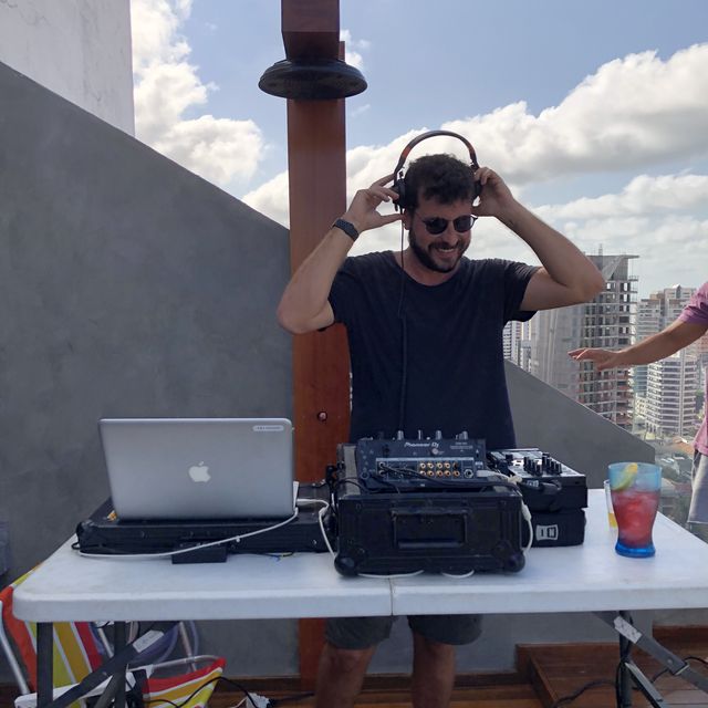 Leo Reis tocando num terraço, com a cidade ao fundo