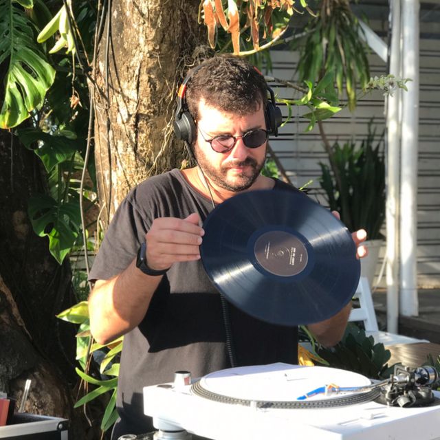 Leo Reis segurando um disco de vinil ao ar livre